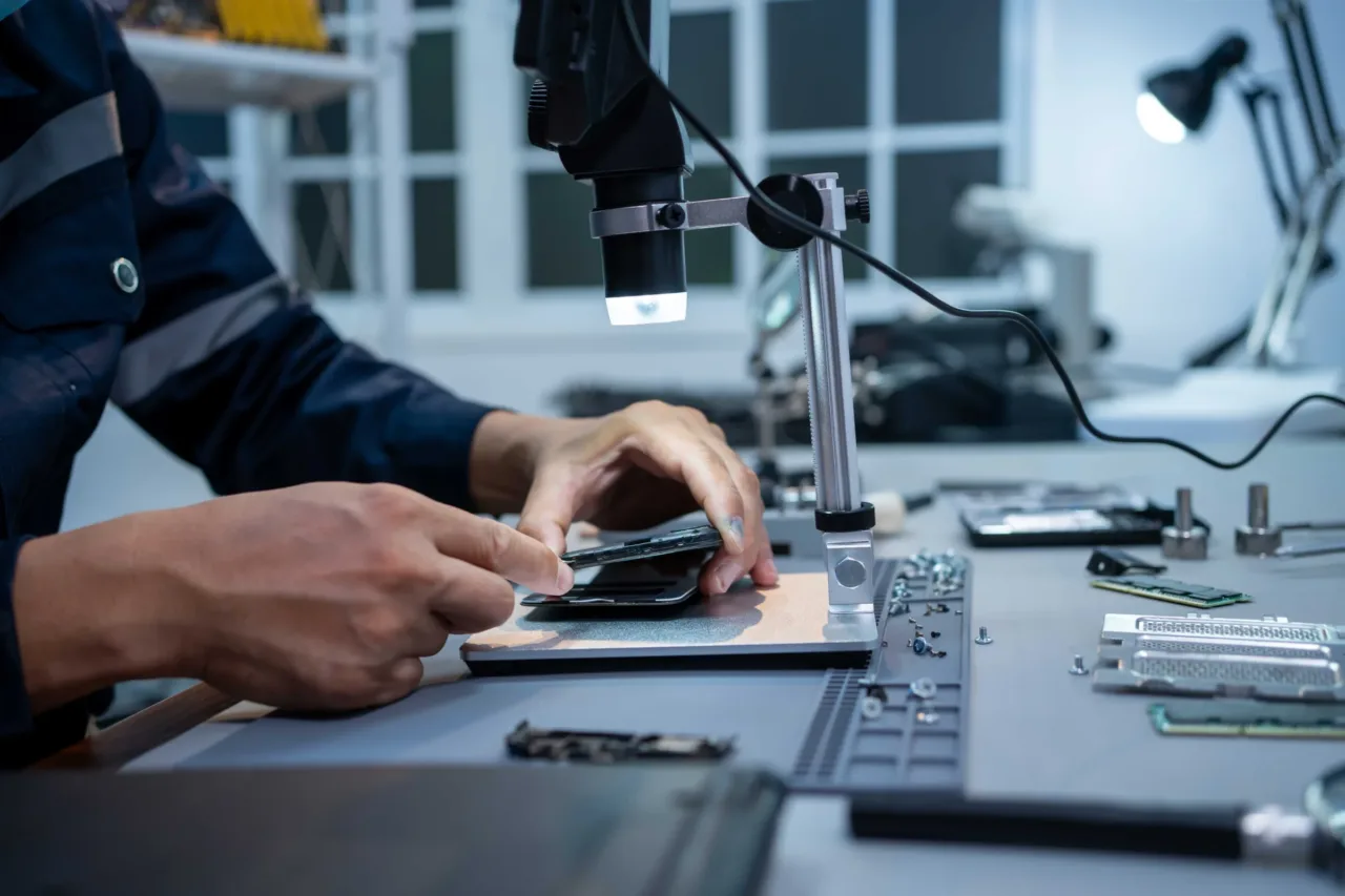 Smartphone-Reparatur unter dem Digitalmikroskop auf der Werkbank